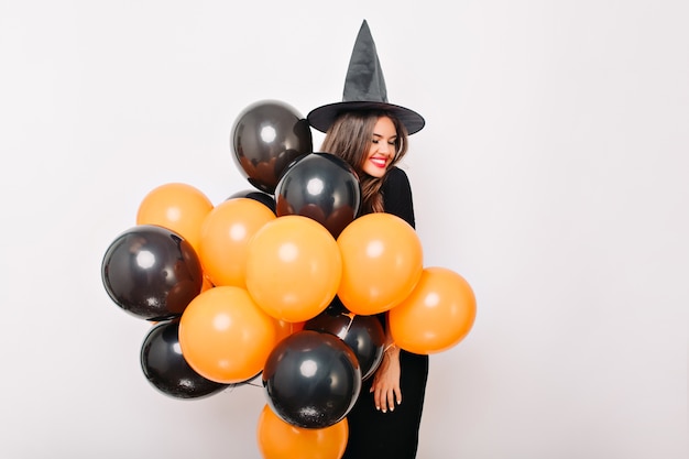 Foto gratuita riendo a una mujer bonita posando con un montón de globos