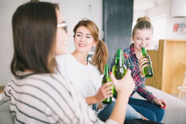 Riendo mujeres jóvenes bebiendo cervezas