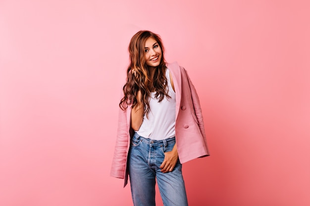 Riendo a niña bonita en chaqueta rosa expresando emociones positivas. retrato de atractiva mujer de jengibre aislada en luz.