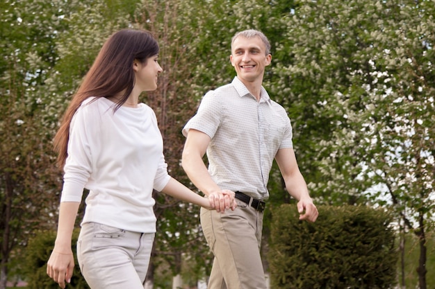 Riendo pareja caminando en el parque