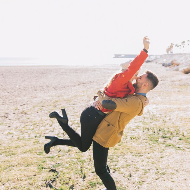 Riendo pareja juguetona en la orilla del mar