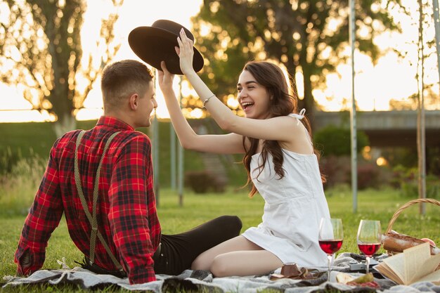 Riendo, sonriendo. Pareja joven caucásica disfrutando juntos de fin de semana en el parque el día de verano