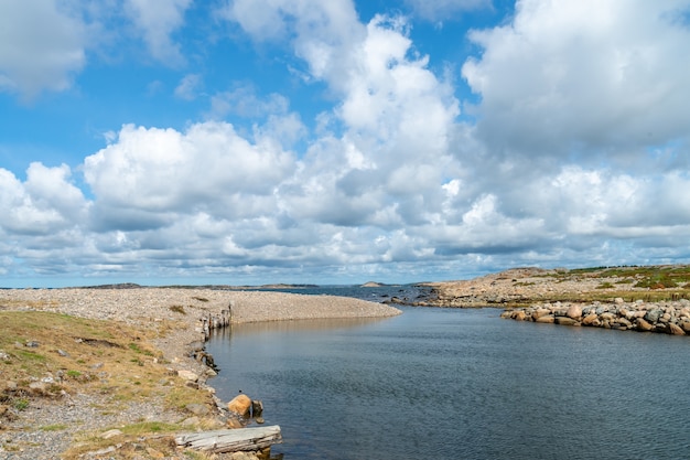 Río rodeado de rocas bajo la luz del sol y un cielo nublado durante el día