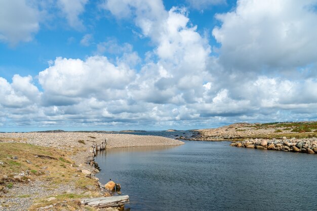 Río rodeado de rocas bajo la luz del sol y un cielo nublado durante el día