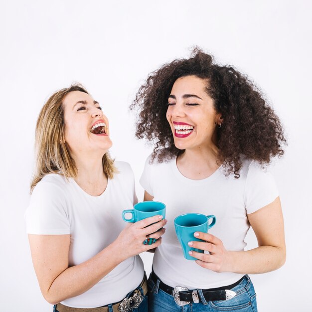 Risa de madre e hija con tazas