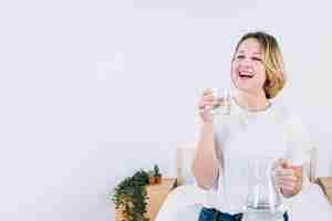 Foto gratuita risa mujer con agua en el dormitorio