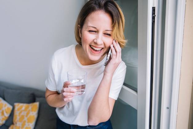 Foto gratuita risa a mujer con agua hablando por teléfono