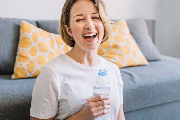 Risa de mujer con botella de agua