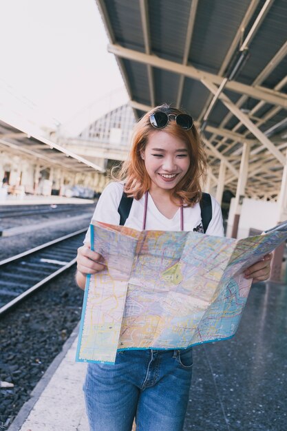 Risa de mujer con mapa en el ferrocarril