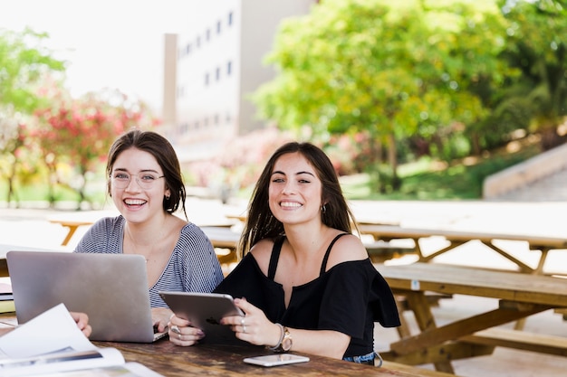 Foto gratuita risas de mujeres con dispositivos digitales