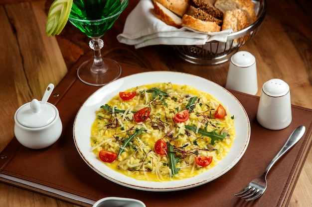 risotto con tomate champiñones queso rúcula tarhun limonada sal pimienta y pan en la mesa