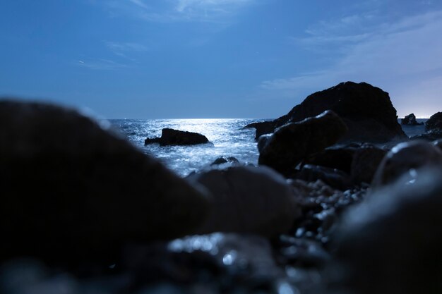 Rocas borrosas en el agua por la noche