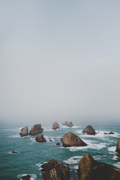 rocas en el océano con paisaje brumoso