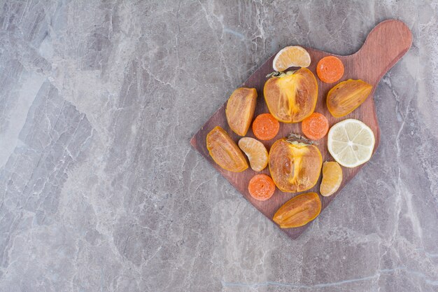 Rodajas de caqui, limón, mandarina y caramelos a bordo.