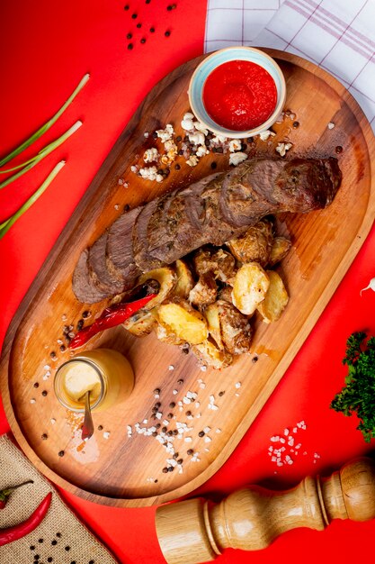 Rodajas de carne frita con papas fritas y salsa de tomate