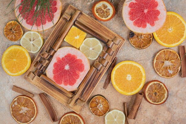 Rodajas de cítricos en marco de imagen con racimo de frutas. Foto de alta calidad