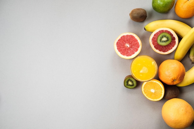 Rodajas de cítricos naranja y pomelo con jugo sobre fondo gris con copyspace Vista superior plana