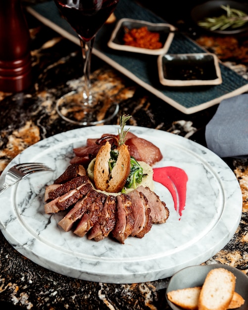 Rodajas de filete de cordero servidas con puré de papa