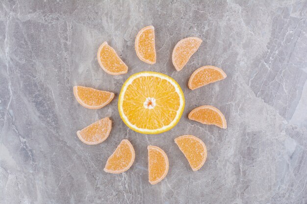 Foto gratuita rodajas frescas de naranja con mermeladas dulces sobre fondo de mármol.