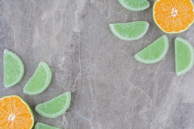 Rodajas frescas de naranja con mermeladas dulces sobre fondo de mármol.