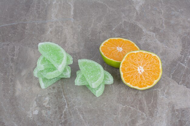 Foto gratuita rodajas frescas de naranja con mermeladas dulces sobre fondo de mármol.