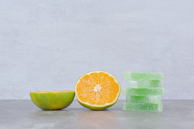 Rodajas frescas de naranja con mermeladas dulces sobre fondo de mármol.