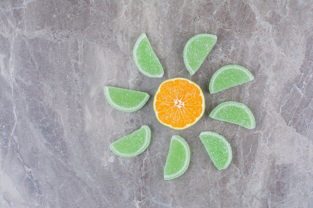 Rodajas frescas de naranja con mermeladas dulces sobre fondo de mármol.