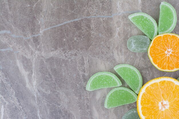 Rodajas frescas de naranja con mermeladas dulces sobre fondo de mármol.