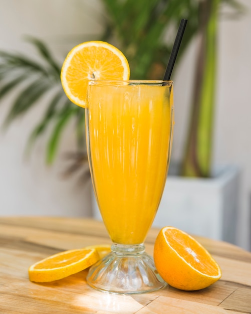 Foto gratuita rodajas de frutas cerca de vaso de bebida en la mesa