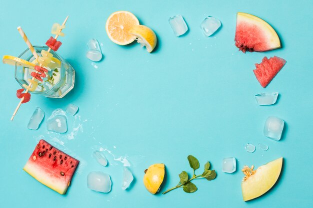 Rodajas de frutas entre hielo y título de verano sobre vidrio.