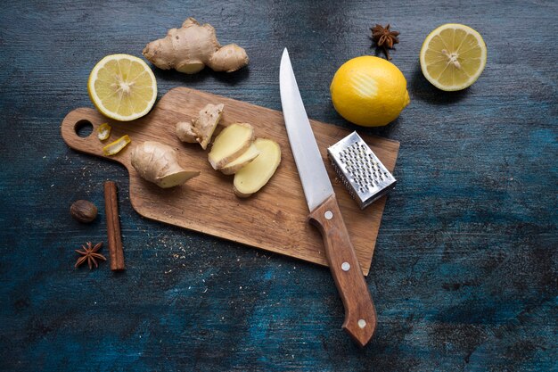 Rodajas de jengibre sobre tabla de madera con limón