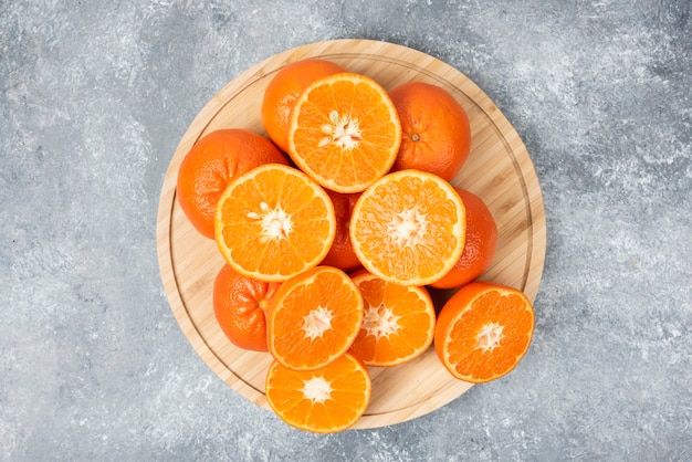 Rodajas de jugosas frutas naranjas frescas en una placa de madera.