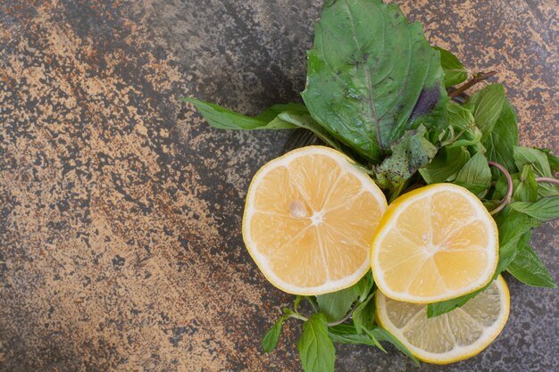 Rodajas de limón con menta en espacio de mármol