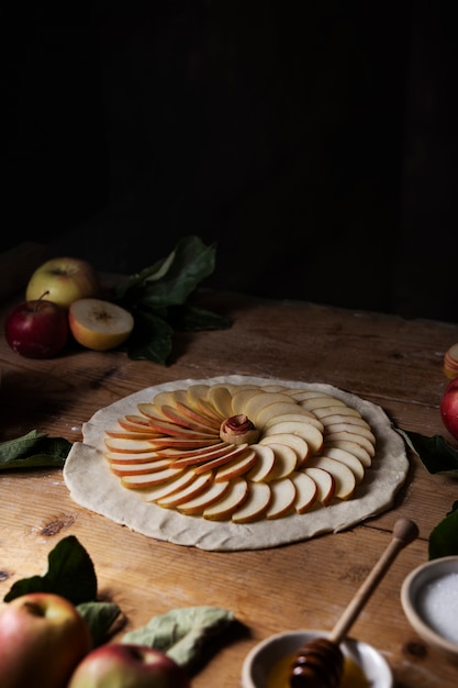 Foto gratuita rodajas de manzana de alto ángulo sobre masa