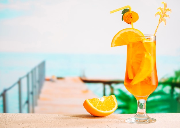 Rodajas de naranja madura y vaso de apetitosa bebida cítrica jugosa
