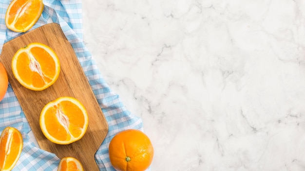 Rodajas de naranja sobre tabla de madera con espacio de copia