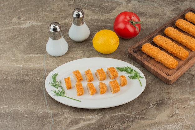 Rodajas de nuggets de pollo con tomate, limón, sal y pimienta.