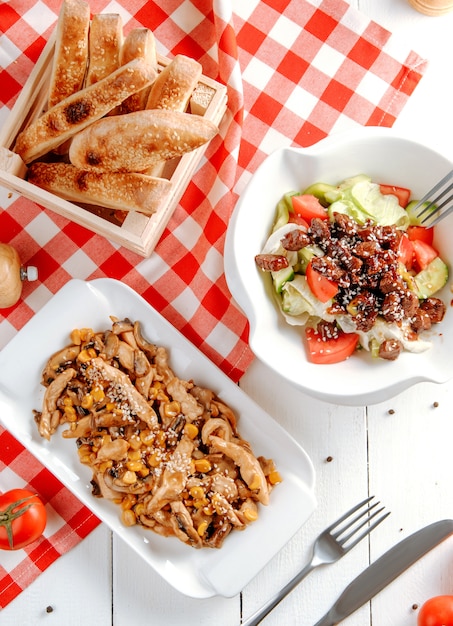 Rodajas de pechuga de pollo frito con ensalada de maíz y vegetales