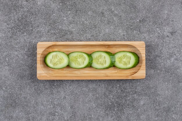 Rodajas de pepino saludable orgánico fresco sobre tabla de madera