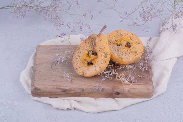 Rodajas de pera con hierbas y especias sobre una tabla de madera