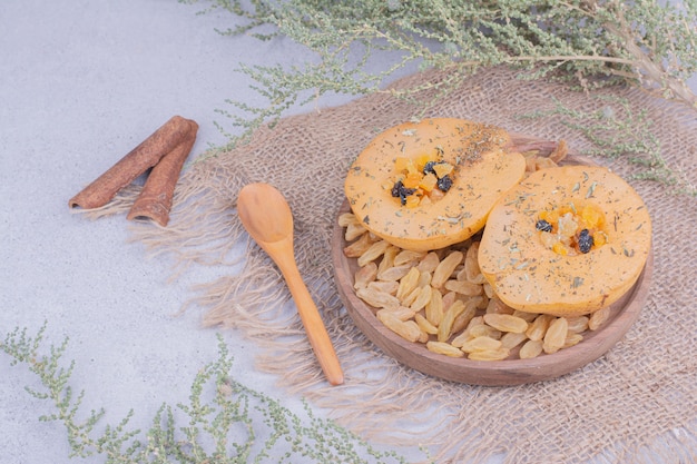 Rodajas de pera en un plato de madera con pasas y canela