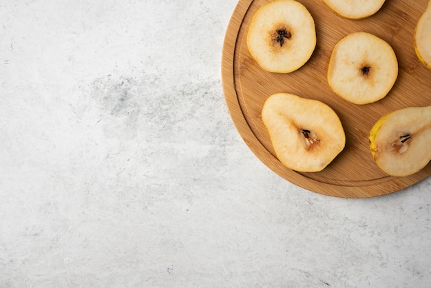 Rodajas de pera en un plato de madera.