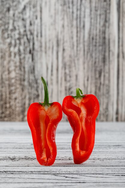 Rodajas de pimiento rojo en la pared de madera sucia y blanca. vista lateral.