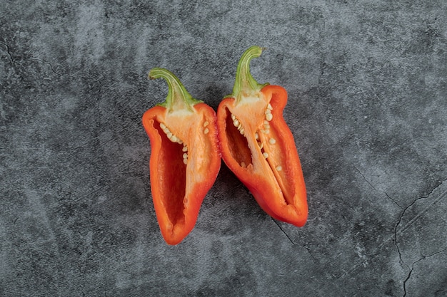 Rodajas de pimiento rojo sobre un fondo gris.