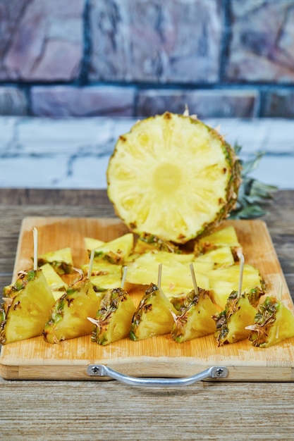 Foto gratuita rodajas de piña sobre tabla de madera