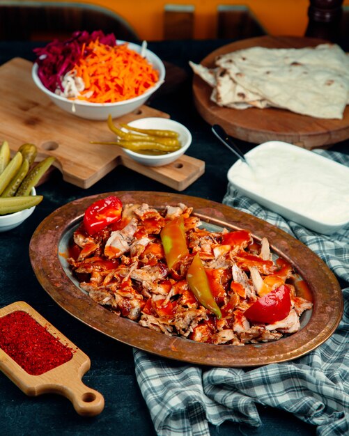 Rodajas de pollo doner adornadas con salsa de tomate, pimiento y tomate fresco