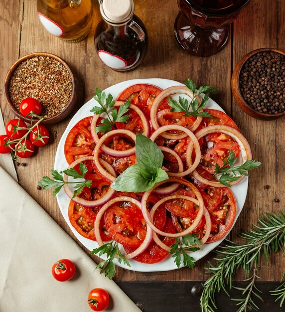 Rodajas de tomate y cebolla con hierbas