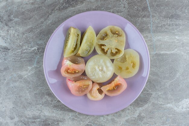 Rodajas de tomate enlatado caseras. Tomates rojos y verdes.