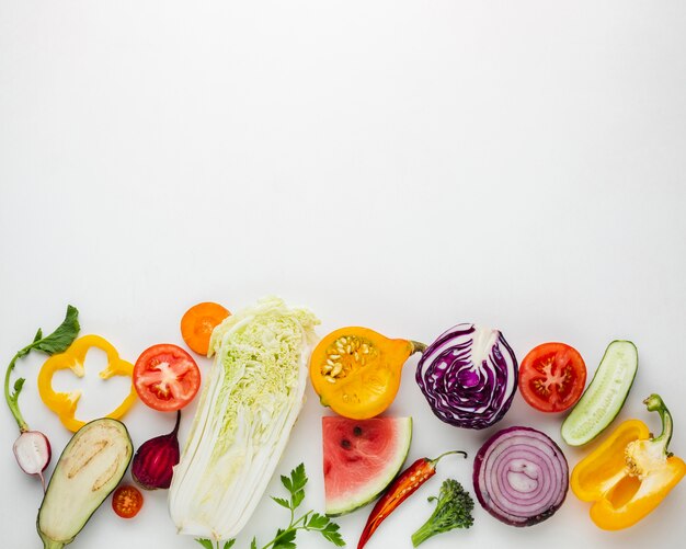 Rodajas de verduras sobre fondo blanco con espacio de copia