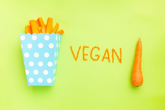 Rodajas de zanahorias en bolsa de papas fritas sobre fondo verde